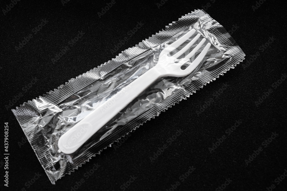 Disposable plastic fork on a dark background. Disposable plastic fork on a dark background.
