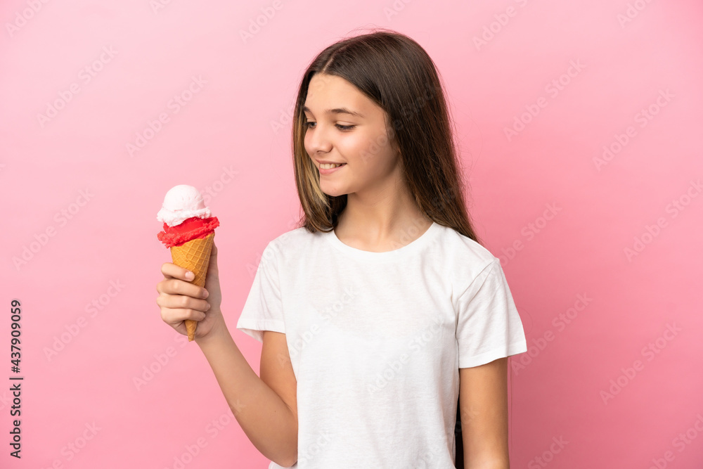 Little girl with a cornet ice cream over isolated pink background looking side Little girl with a cornet ice cream over isolated pink background looking side