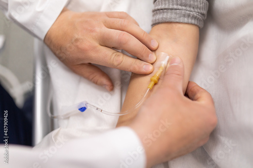 Hand of patient in serious condition is given a medicine through a dropper healthcare background with an intravenous system