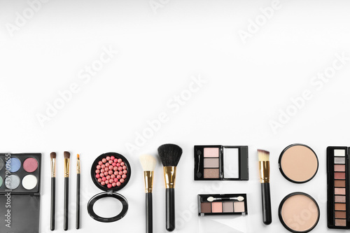 Flat lay composition with makeup brushes on white background, space for text