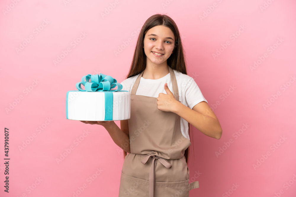 Little girl with a big cake over isolated pink background giving a thumbs up gesture Little girl with a big cake over isolated pink background giving a thumbs up gesture