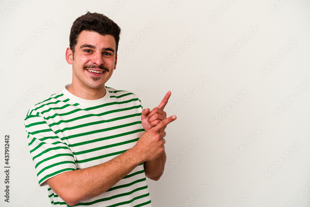 Young caucasian man isolated on white background shocked pointing with index fingers to a copy space. Young caucasian man isolated on white background shocked pointing with index fingers to a copy space.