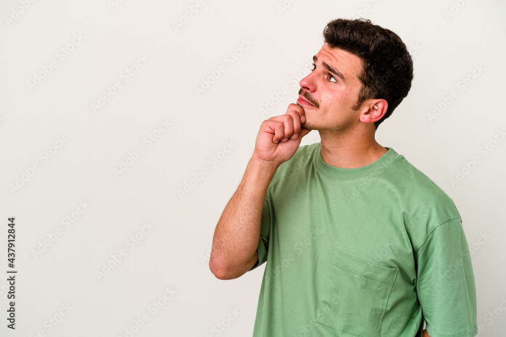 Young caucasian man isolated on white background relaxed thinking about something looking at a copy space. Young caucasian man isolated on white background relaxed thinking about something looking at a copy space.
