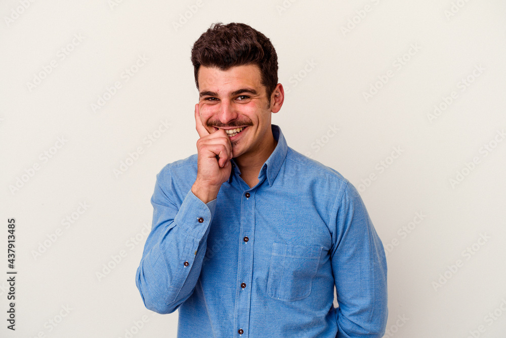 Young caucasian man isolated on white background smiling happy and confident, touching chin with hand. Young caucasian man isolated on white background smiling happy and confident, touching chin with hand.