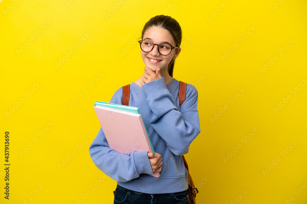 Student kid woman over isolated yellow background looking to the side and smiling Student kid woman over isolated yellow background looking to the side and smiling