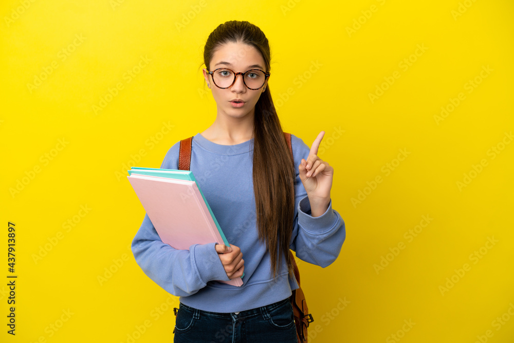Student kid woman over isolated yellow background intending to realizes the solution while lifting a finger up Student kid woman over isolated yellow background intending to realizes the solution while lifting a finger up