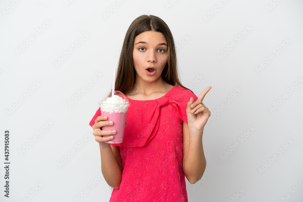 Little girl with strawberry milkshake over isolated white background intending to realizes the solution while lifting a finger up Little girl with strawberry milkshake over isolated white background intending to realizes the solution while lifting a finger up