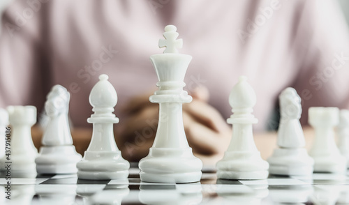 White chess pictures laid out on a chessboard  concept comparing playing chessboard to business administration. Businessmen playing chess are likened to business planning and problem-solving.