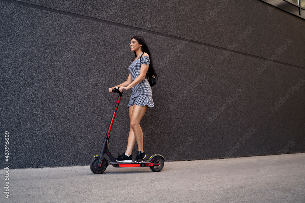 Pretty attractive girl in short dress riding e scooter Pretty attractive girl in short dress riding e scooter