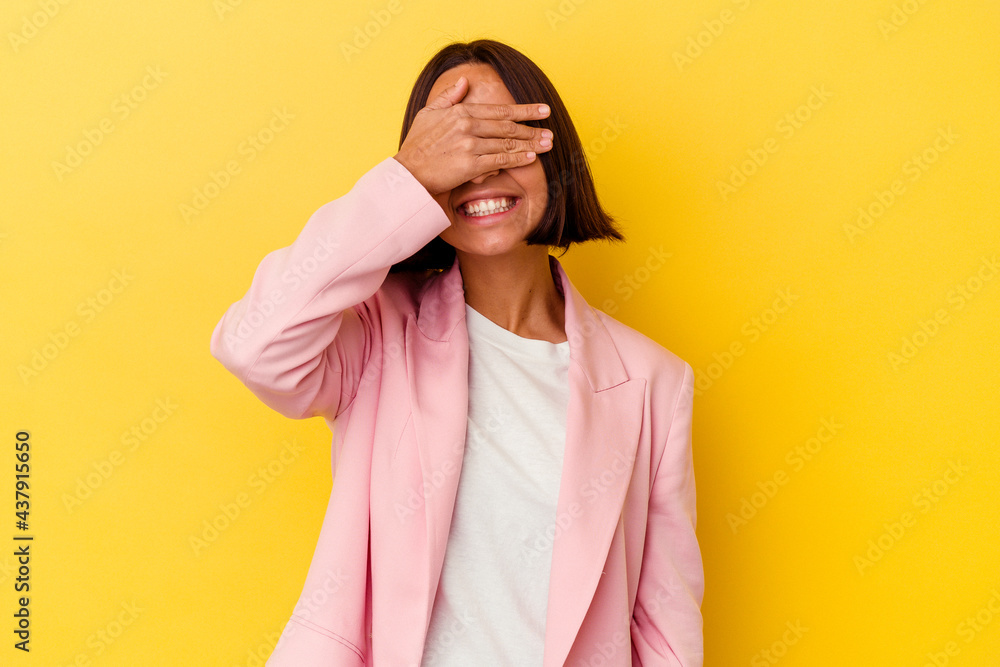 Young mixed race woman isolated on yellow background laughs joyfully keeping hands on head. Happiness concept.