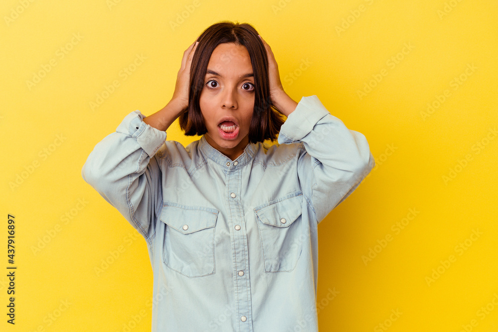 Young mixed race woman isolated on yellow background screaming, very excited, passionate, satisfied with something. Young mixed race woman isolated on yellow background screaming, very excited, passionate, satisfied with something.