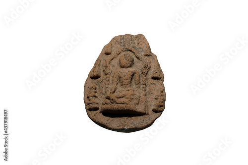 Ancient votive tablet, the Buddha seated in Subduing Mara gesture beneath the Mahabodhi Sikhara of Budh Gaya with his two disciples, isolated on white background. photo