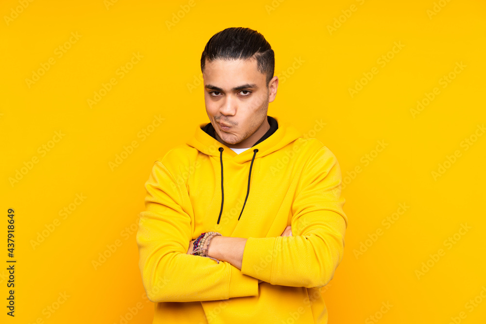 Asian handsome man isolated on yellow background laughing