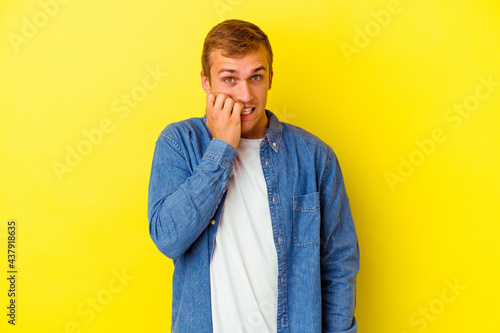 Young caucasian man isolated on yellow background