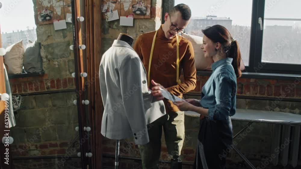 Dollyin shot of male fashion designer with prosthetic leg inspecting