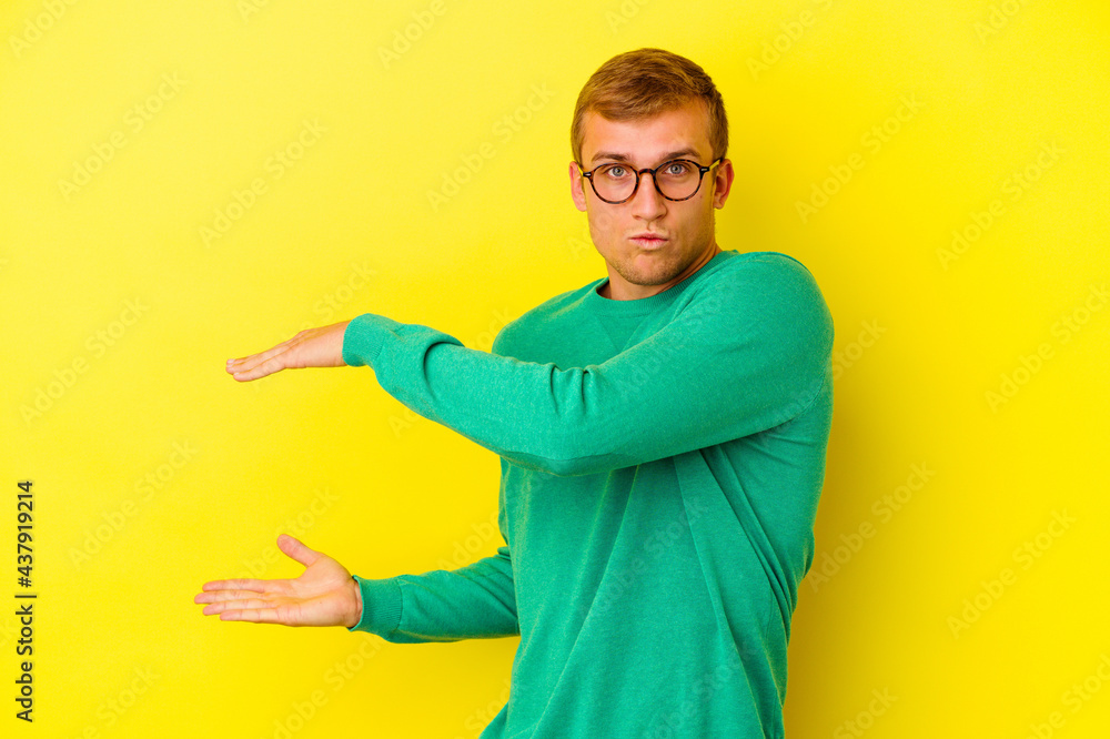 Young caucasian man isolated on yellow background Young caucasian man isolated on yellow background