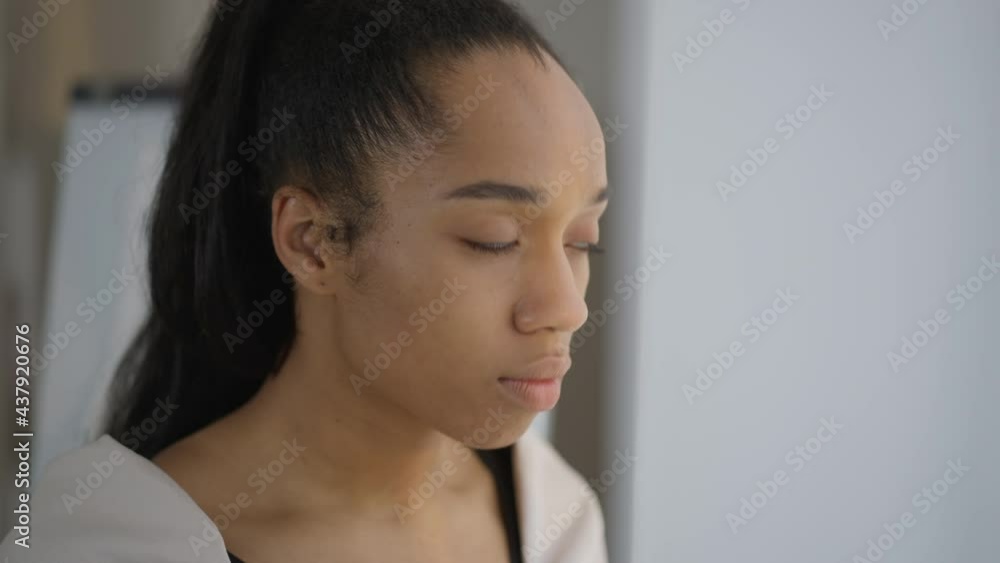 Close-up face of concentrated thoughtful young beautiful woman looking out the window planning business idea. Headshot portrait of confident African American millennial thinking indoors Close-up face of concentrated thoughtful young beautiful woman looking out the window planning business idea. Headshot portrait of confident African American millennial thinking indoors