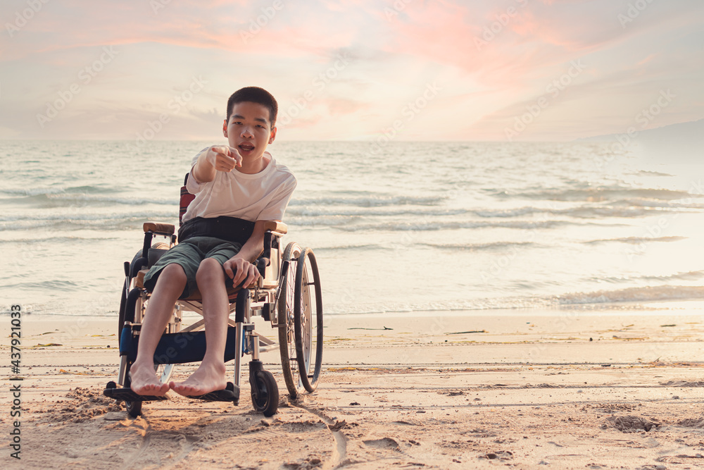 Asian disabled child on wheelchair is fun with activity on the beach in family holiday travel and learning about nature around the sea beach, Lifestyle in the education age,Happy disabled kid concept.