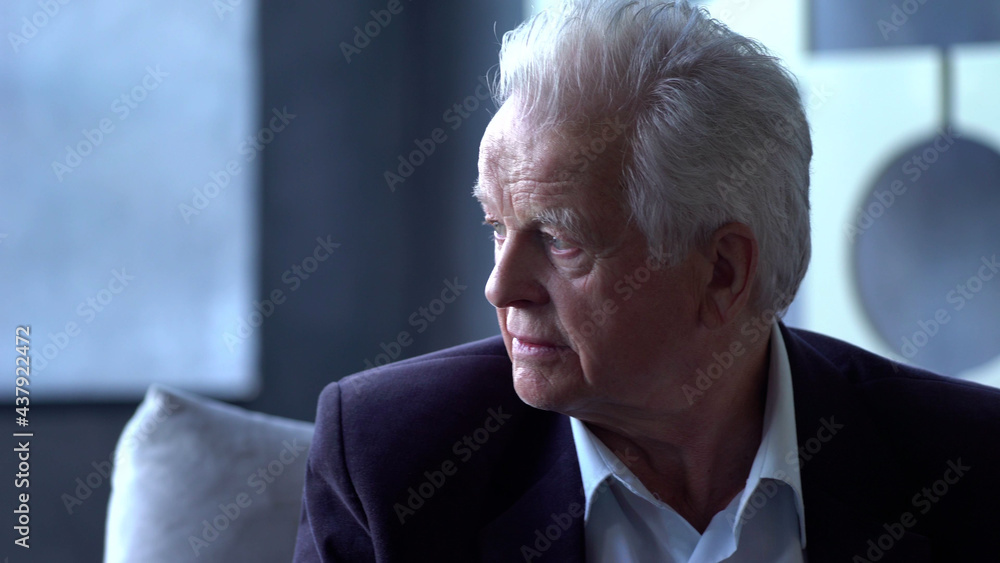 Portrait of elderly man sitting on sofa and looking away Portrait of elderly man sitting on sofa and looking away