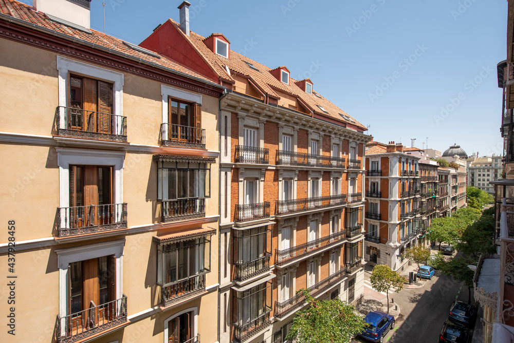 Facades of buildings with viewpoints and balconies with cast iron railings in the center of Madrid