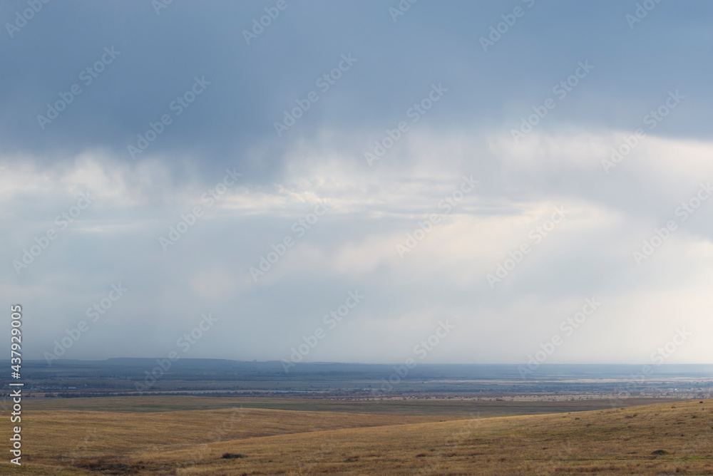 Panoramic view of the vast fields under the storm clouds. The concept of spaciousness and minimalism.. Natural background