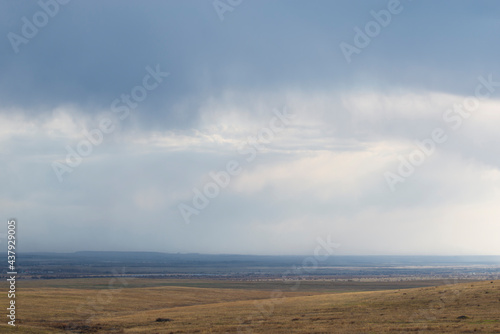 Panoramic view of the vast fields under the storm clouds. The concept of spaciousness and minimalism.. Natural background