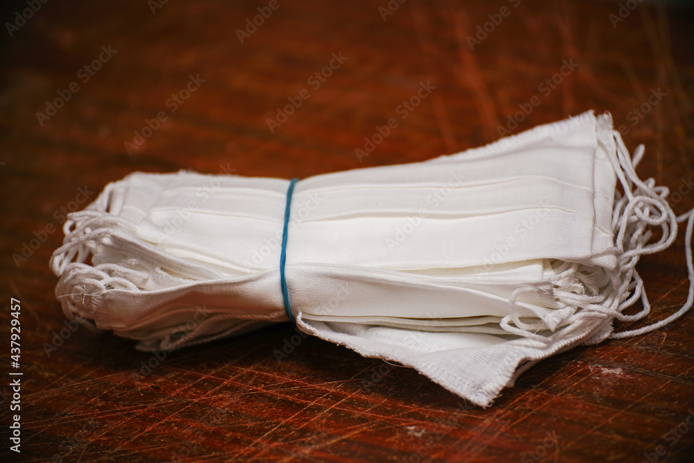 A stack of medical protective masks on a scratched wooden table