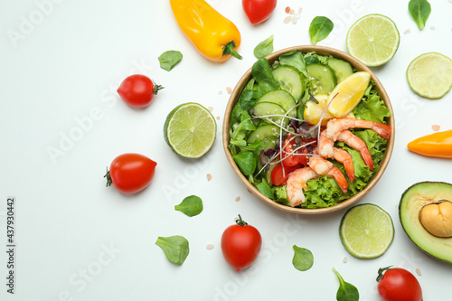 Tasty shrimp salad and ingredients on white background