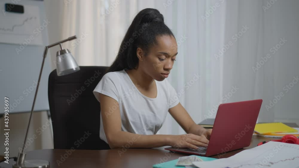 Young exhausted tired African American woman typing on keyboard closing laptop putting head on table. Portrait of overworking burnt out freelancer in home office taking a nap Young exhausted tired African American woman typing on keyboard closing laptop putting head on table. Portrait of overworking burnt out freelancer in home office taking a nap