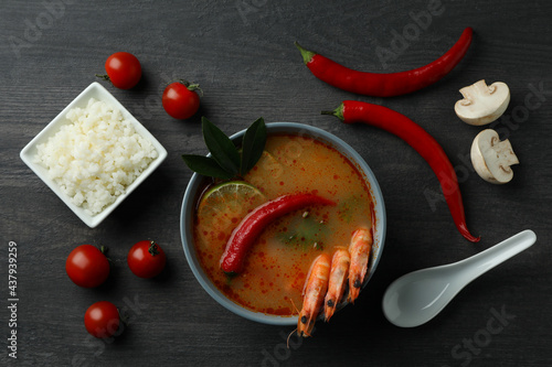 Tom yum soup and ingredients on dark wooden background