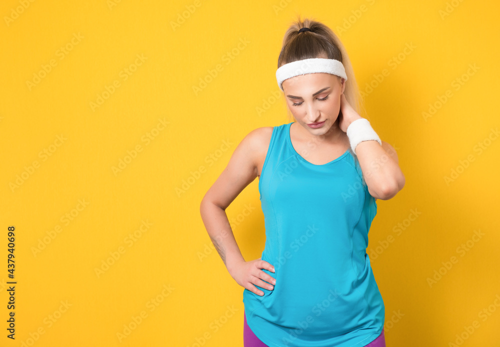 Fitness young woman posing and looking to side, isolated on yellow background. Half length of sportswoman ready for exercising. Athletic female person. 80s styling Fitness young woman posing and looking to side, isolated on yellow background. Half length of sportswoman ready for exercising. Athletic female person. 80s styling