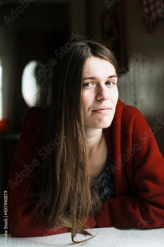 Young woman in the red with long hair, portrait in the her house.