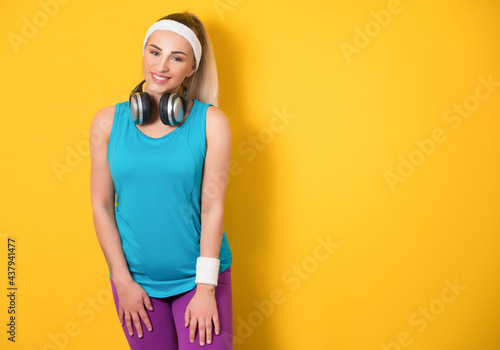 Front view portrait of happy fitness young woman,women,young women,only women,one woman only,young adult, isolated on yellow background. Athletic female person. 80s styling