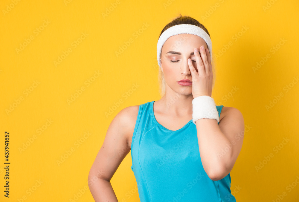 Exhausted fitness woman resting after workout at gym, keeps hand on forehead. Sport female taking break after training session, isolated on yellow background. 80s styling Exhausted fitness woman resting after workout at gym, keeps hand on forehead. Sport female taking break after training session, isolated on yellow background. 80s styling