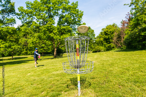 Disc golf is a flying disc sport in which players throw a disc at a target; played using rules like golfs.  photo