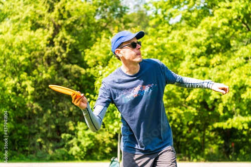 Bild auf Leinwand Disc golf is a flying disc sport in which players throw a disc at a target; it is played using rules similar to golf