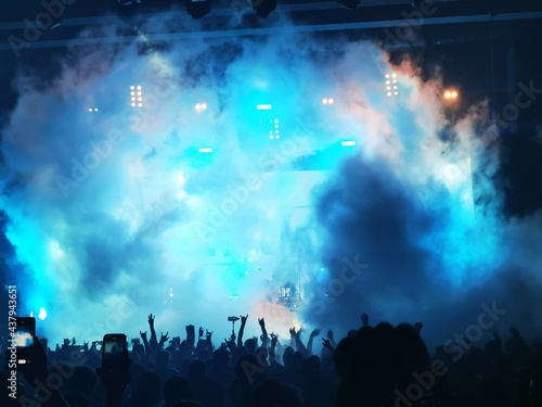 silhouettes of concert crowd in front of bright stage lights