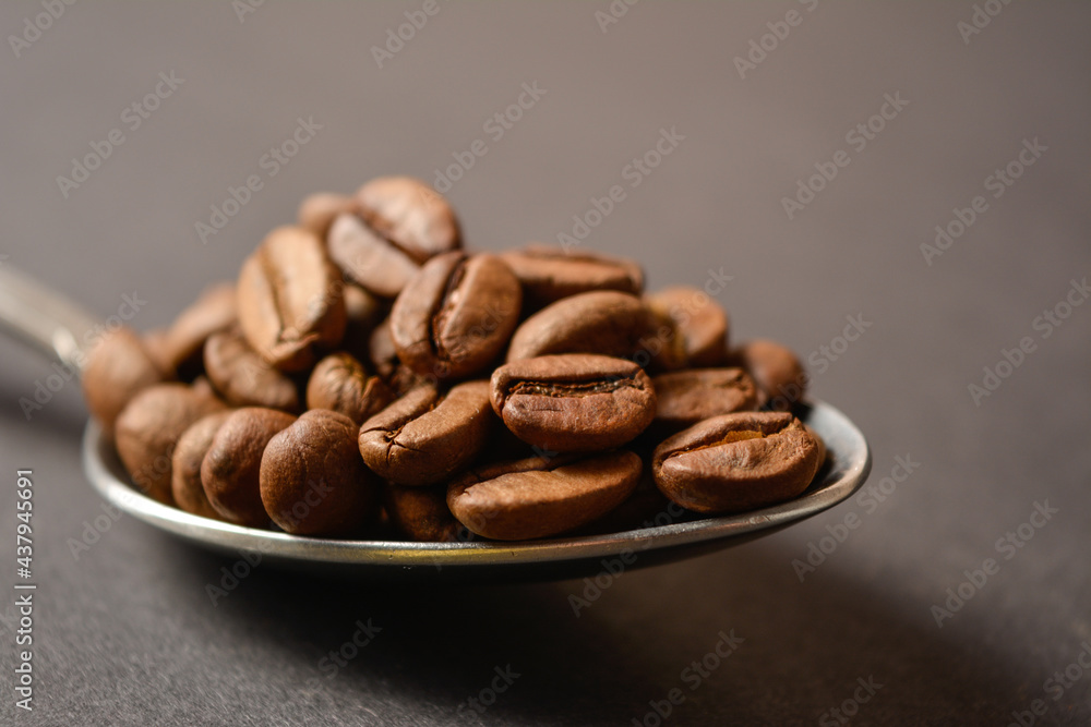 Macro shot of Roasted coffee beans served in silver vintage stainless steel spoon on dark background. High quality organic aroma seeds. Copy space text image
Macro shot of Roasted coffee beans served in silver vintage stainless steel spoon on dark background. High quality organic aroma seeds. Copy space text image