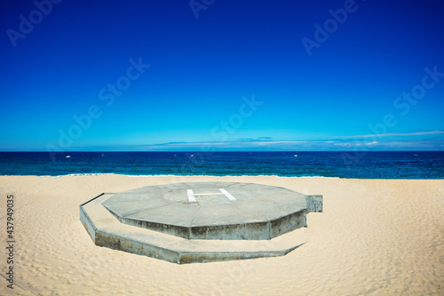 Heliport view on the sand beach over blue ocean photo