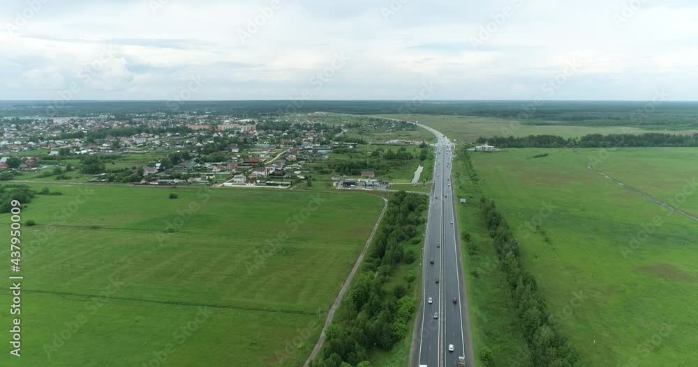Car traffic on a four-lane road on a summer cloudy day Car traffic on a four-lane road on a summer cloudy day