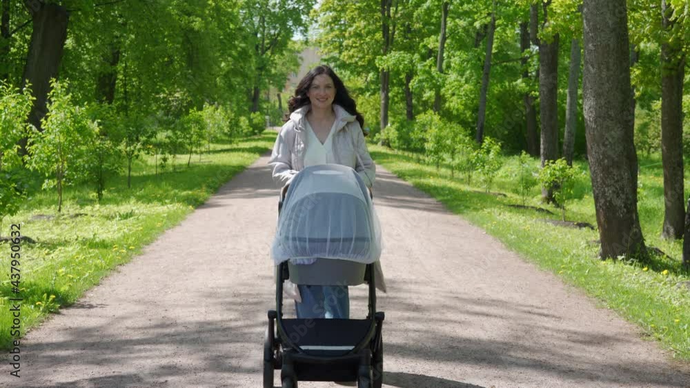 Mother with baby stroller on a walk in spring park, mom pushing baby carriage in Alexander Park in the town of Tsarskoye Selo, Pushkin. High quality 4k footage Mother with baby stroller on a walk in spring park, mom pushing baby carriage in Alexander Park in the town of Tsarskoye Selo, Pushkin. High quality 4k footage