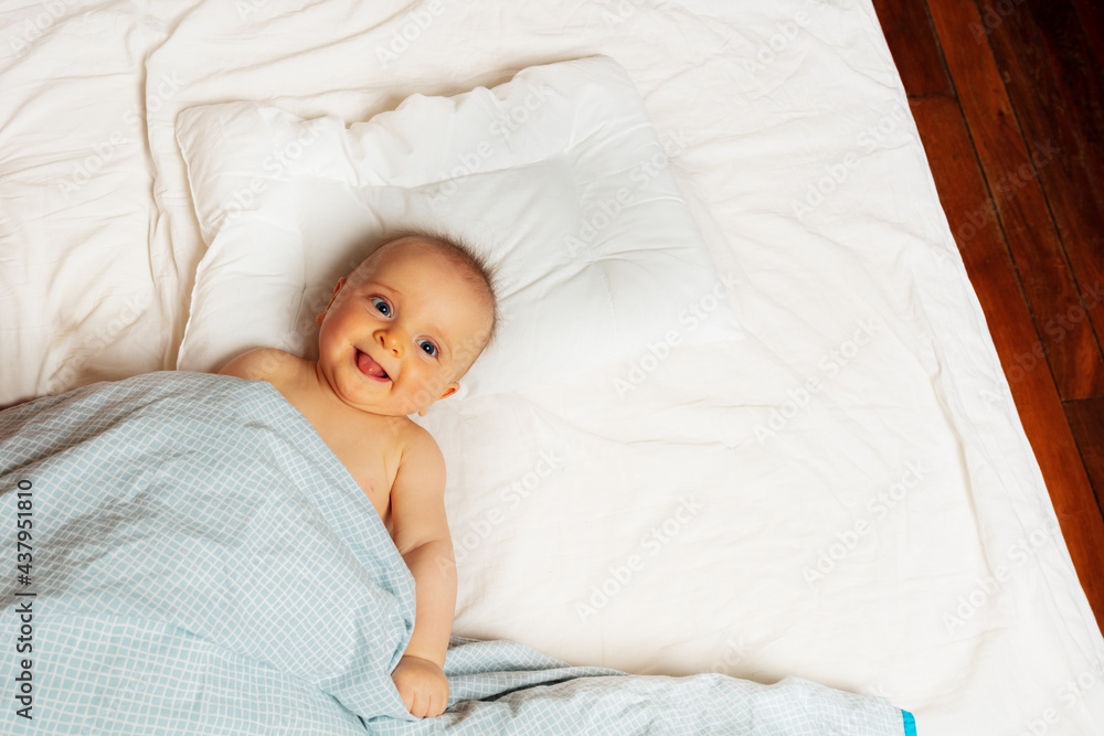 Laughing baby little girl in bed view from above Laughing baby little girl in bed view from above