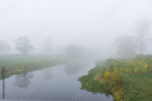 Foggy morning on a river with an autumn landscape