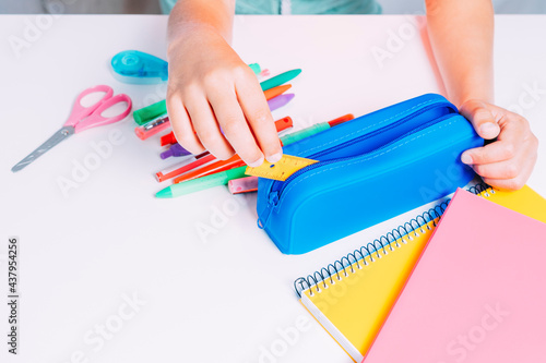 Obraz na plátně close up of a child's hands taking out of his blue pencil case a small ruler