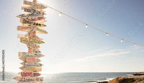 Obraz na plátně Multiple signs  tourist destinations on a wooden pole in the beach