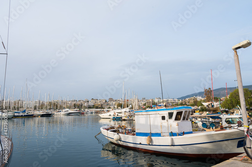 Yacht and boats parking in harbor. White sailing yachts at the pier. Sea yacht club. Aegean sea. Athens, Greece. Cloudy day.