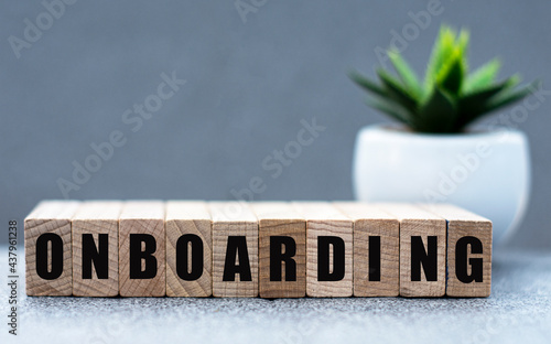 ONBOARDING - word on wooden cubes on a gray background with a cactus photo