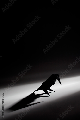 Bird origami made from colored paper isolated over black background