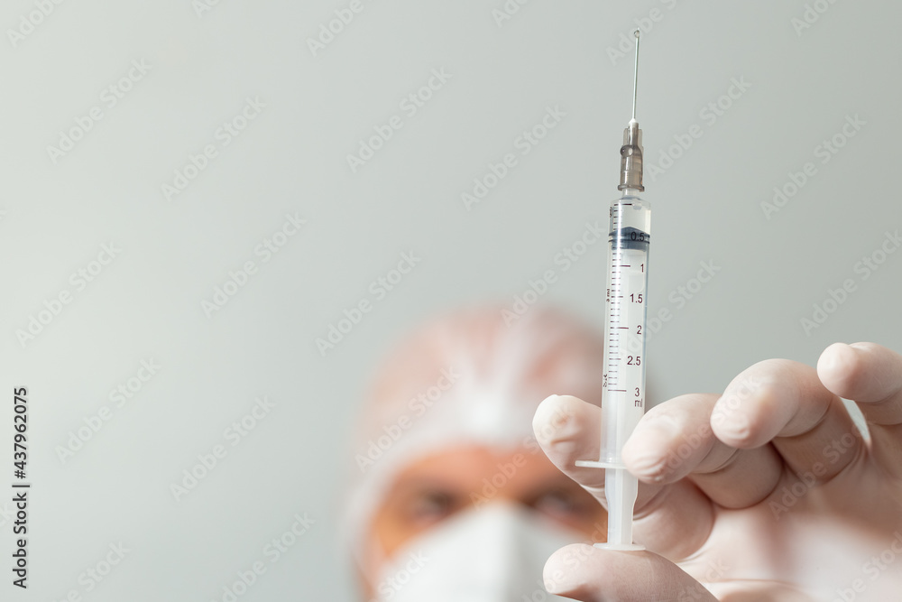 Médico segurando uma seringa com vacina em primeiro plano. Médico segurando uma seringa com vacina em primeiro plano.