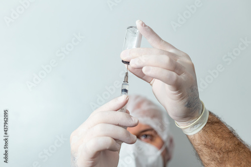 Médico preparando uma seringa com vacina em primeiro plano. photo